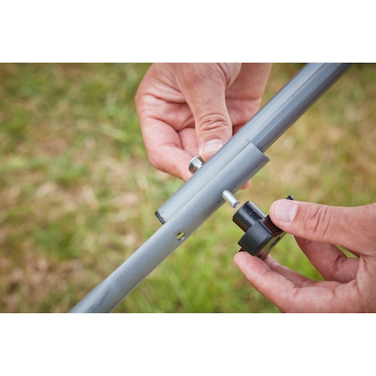 BLACKDECKER BCMW3318N handle assembly close-up with bolt and knob being attached outdoors.