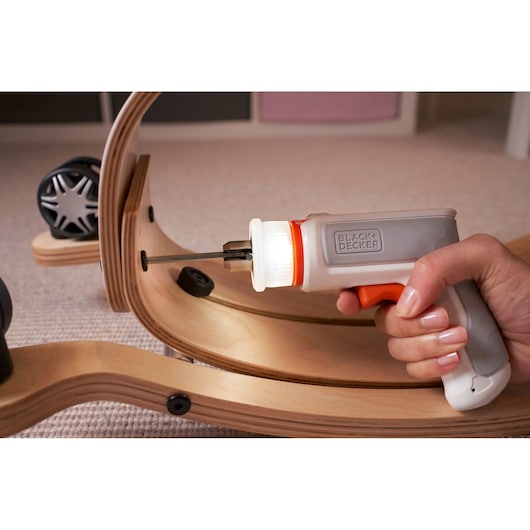 BLACK+DECKER BCRTA01 cordless screwdriver with LED light being used to assemble a wooden toy.
