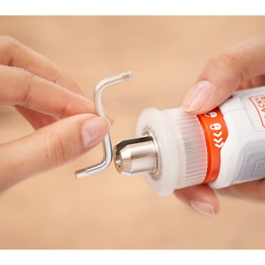 BLACKDECKER BCRTA01 photography showing hand inserting hex key into drill chuck.
