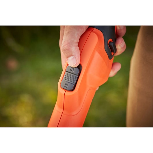 Close-up photo of BLACKDECKER BCSTA536B garden tool handle with speed control switch being adjusted by hand.