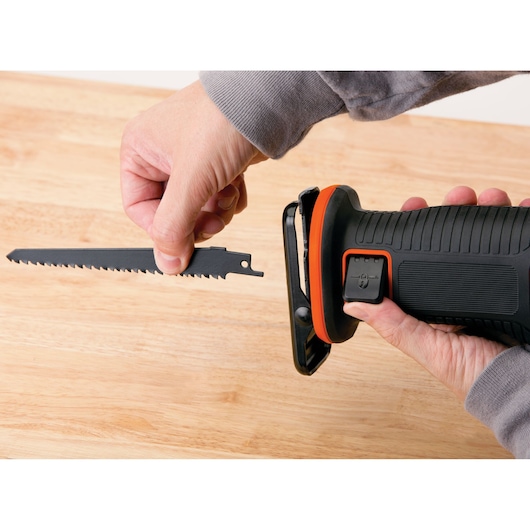 BLACKDECKER BDCR18 reciprocating saw with blade being inserted, close-up on wooden surface.