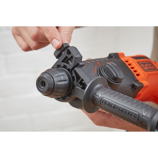 Photo of BLACK+DECKER BEHS01 hammer drill close-up, showing adjustable front handle and side dial, hand adjusting setting.