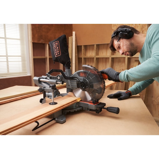BLACK+DECKER BES701 miter saw in use on wood in workshop, side angle.