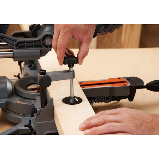 Photo of BLACKDECKER BES701 mitre saw clamping a wooden board in place on a workbench.