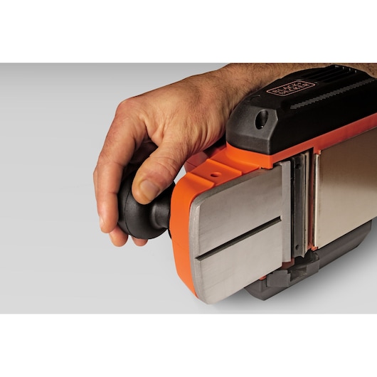 Photo of a hand holding a BLACKDECKER BEW712 electric planer, close-up side view showing the front handle and metal base.