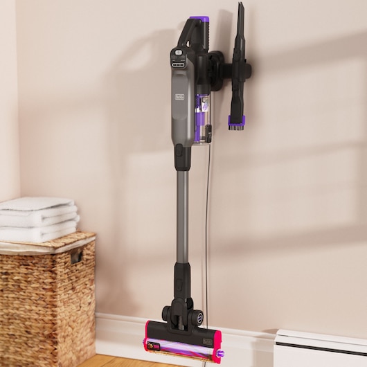 Photo of BLACKDECKER BHFEA640WG cordless stick vacuum cleaner with purple accents mounted on a wall with accessory.