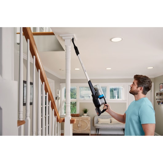 Photo of BLACKDECKER BHFEB520D1 stick vacuum cleaning staircase post inside home.