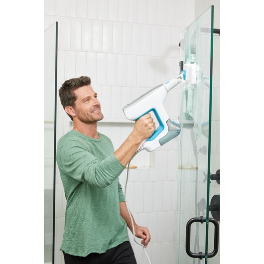 BLACK+DECKER BHSM15FX08 steam cleaner used on glass shower door in bathroom.