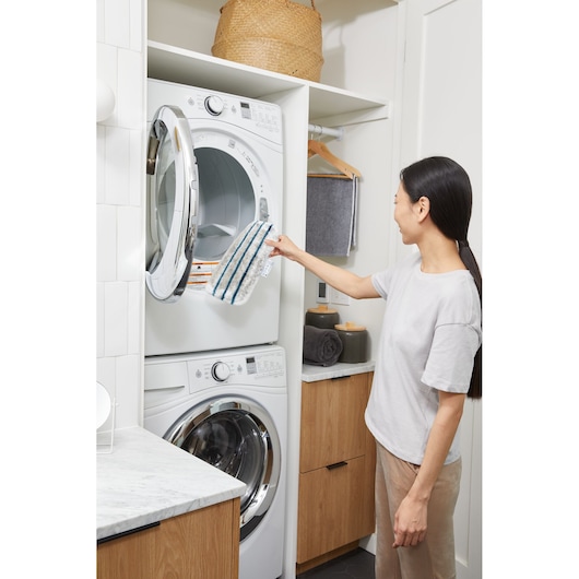 BLACKDECKER BHSM15FX08 steam mop pad being removed from dryer in modern laundry room.