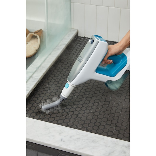 Photo of BLACKDECKER BHSM15FX08 steam cleaner cleaning dark hexagonal tile floor near shower.