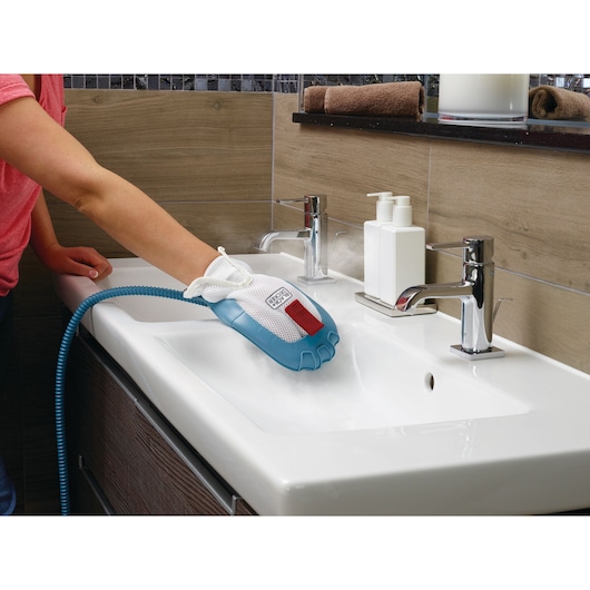 BLACKDECKER BHSM166DSM steam cleaning glove in blue and white used to clean a bathroom sink, left side view.