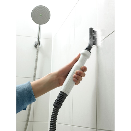 BLACKDECKER BHSM168DSM steam cleaner brushing white shower tile grout, angled hand-held view.