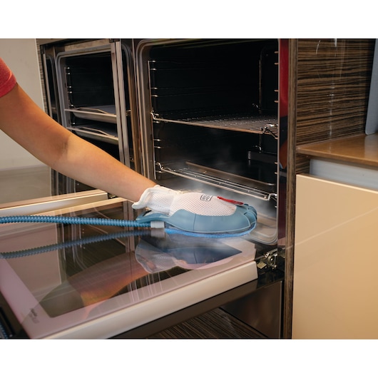 BLACKDECKER BHSM168DSM steam cleaning glove used to clean oven door glass with blue hose attached.