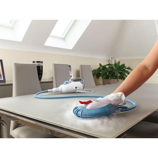 BLACKDECKER BHSM168DSM steam cleaner used to clean a tabletop, blue and white handheld unit with attached hose.