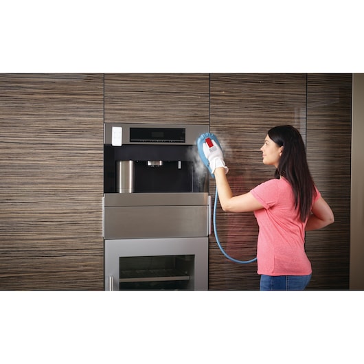 Photo of BLACKDECKER BHSM168DSM steam cleaning glove used to clean a built-in kitchen appliance.
