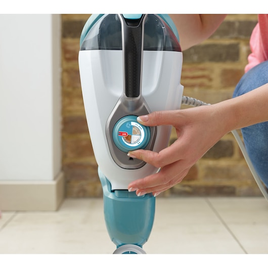 BLACKDECKER BHSM168DSM steam mop close-up, hand adjusting control dial, indoor setting.