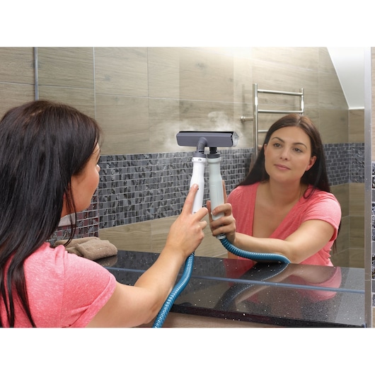 BLACKDECKER BHSM168DSM steam cleaner being used to clean bathroom mirror.