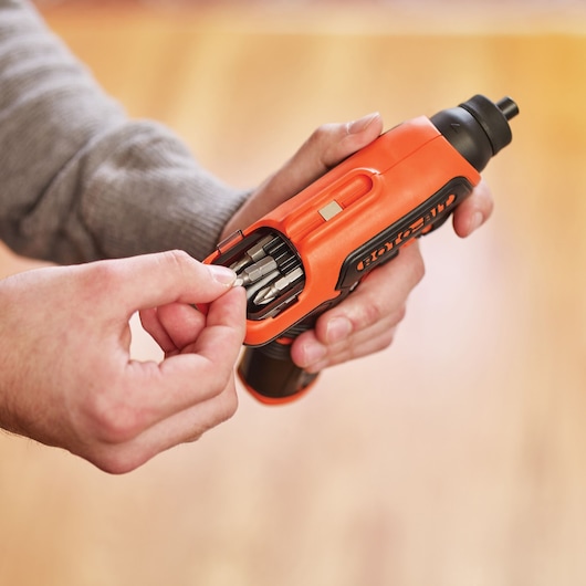 BLACKDECKER CS36BSC cordless screwdriver with built-in bit storage, orange and black, held in hand.