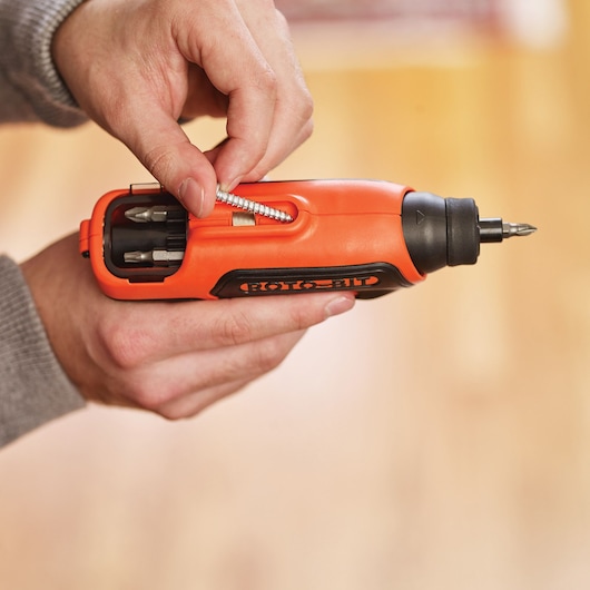 Photo of BLACKDECKER CS36BSC orange cordless screwdriver with accessories compartment, held in hand.