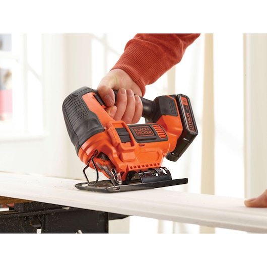 A wooden plank being cut using the BLACK+DECKER® 18V Cordless Pendulum Jigsaw.