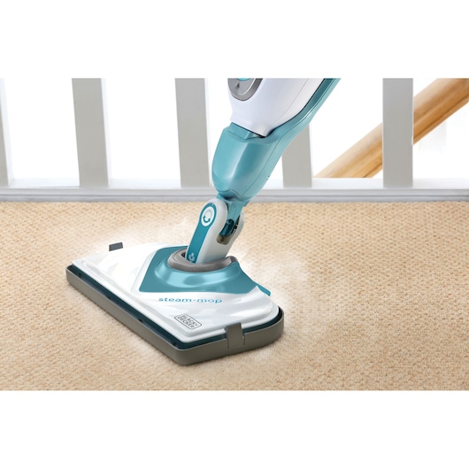 BLACK+DECKER FSMCG steam mop cleaning beige carpet, close-up front angle.