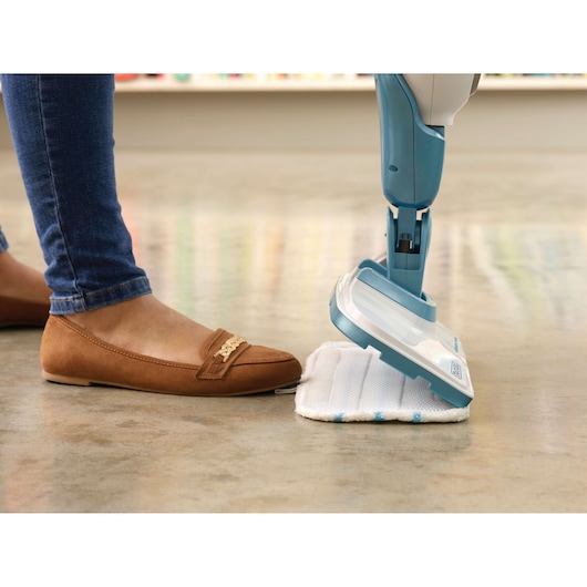 BLACKDECKER FSMH1321 steam mop with white and blue head on floor, shown from side, foot nearby.