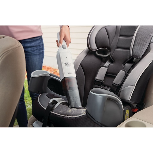 BLACKDECKER HLVC315B11 handheld vacuum cleaning crumbs from a car child seat.