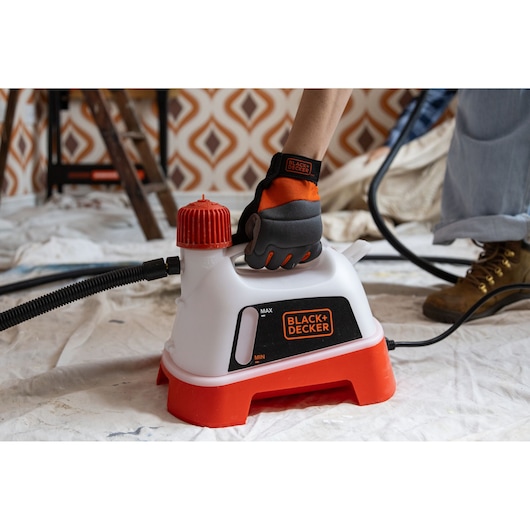 The BLACK+DECKER® 2400W Wallpaper Stripper being placed on a floor.