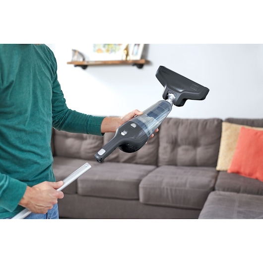 BLACKDECKER NSVA315J handheld vacuum cleaner in living room setting near sofa.