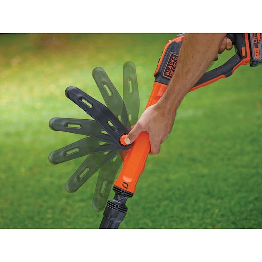 BLACK+DECKER STC1840EPC grass trimmer handle adjustment in use, close-up, on lawn.